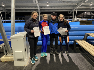 Scheidsrechter Johan den Ouden heeft certificaten uitgereikt voor de baanrecords uitgereikt (vlnr) aan: Anna Catharina Verkaik, Jojanneke den Hartog en Amina Dillmann, die haar eigenbaanrecord op de 1000m verbeterde.